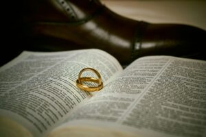 Elegant golden wedding rings resting on an open Bible, symbolizing a spiritual wedding union.